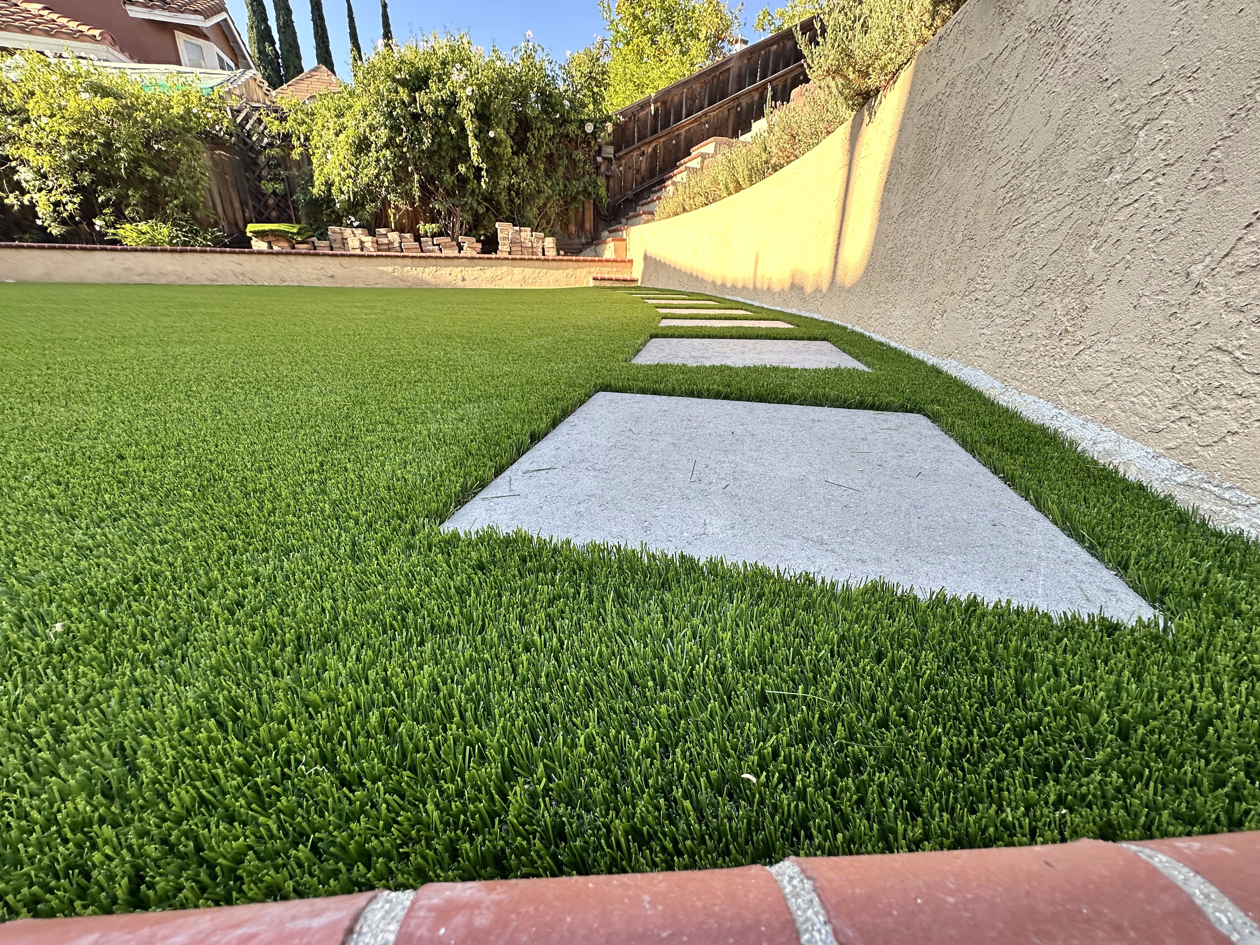 Artificial grass with concrete paver walkway in San Diego, CA by TurboSurfacing